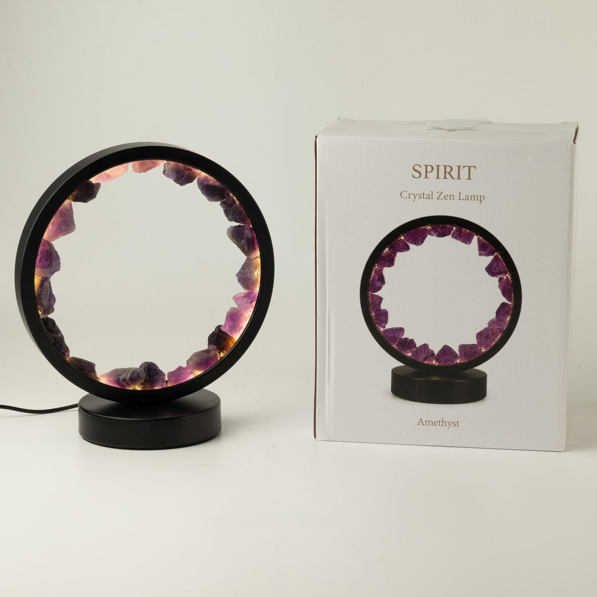 Illuminated amethyst gemstone halo lamp on a black metal stand