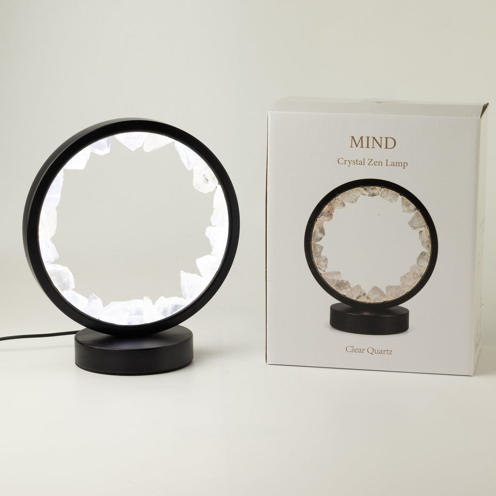 Illuminated clear quartz gemstone halo lamp on a black metal stand