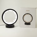 Illuminated clear quartz gemstone halo lamp on a black metal stand