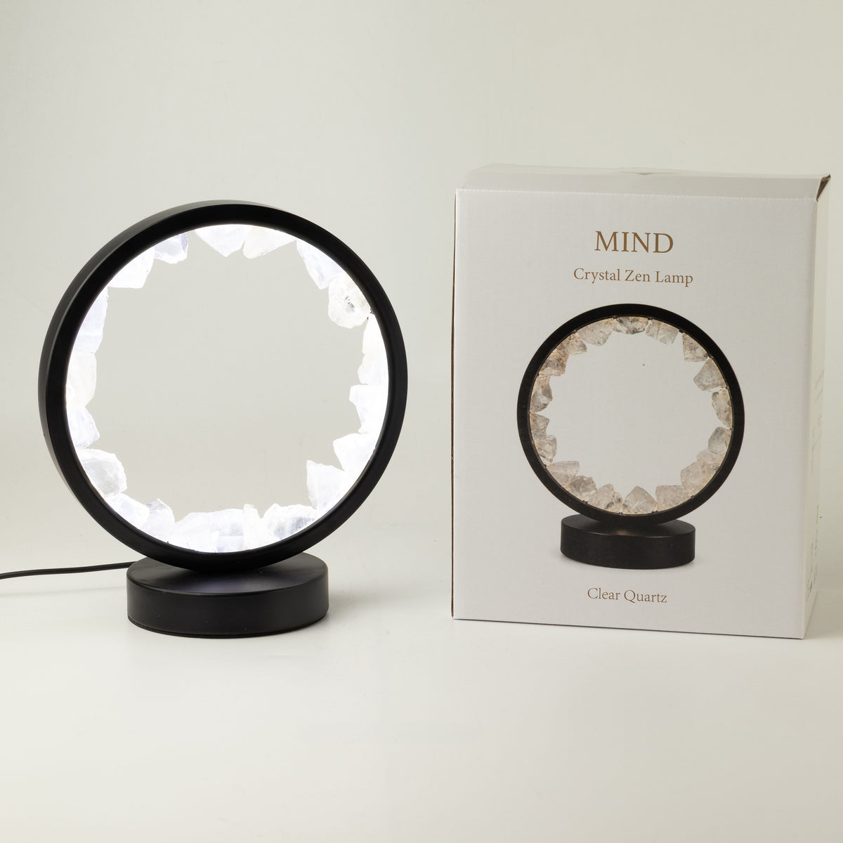 Illuminated clear quartz gemstone halo lamp on a black metal stand