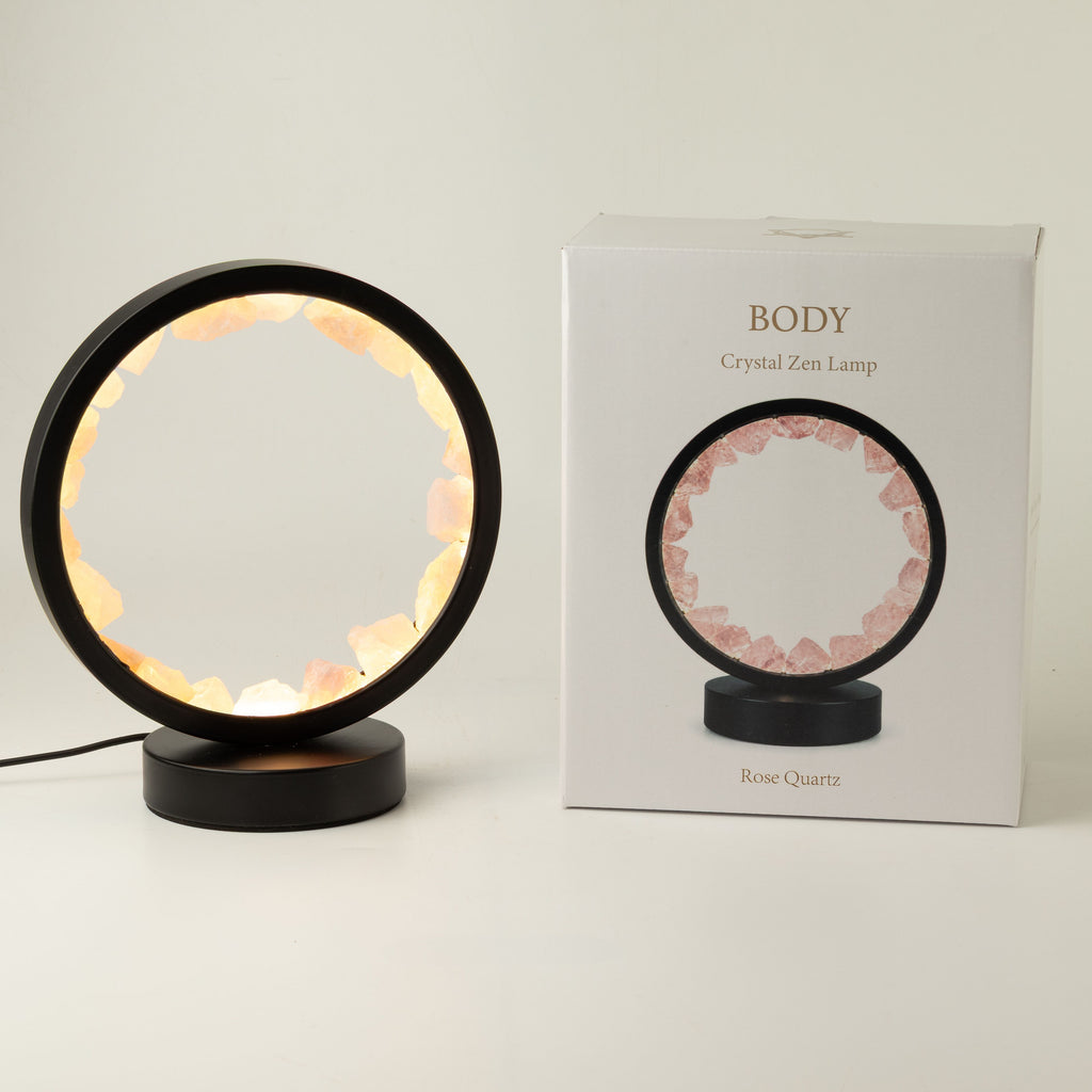 Illuminated rose quartz gemstone halo lamp on a black metal stand