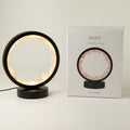 Illuminated rose quartz gemstone halo lamp on a black metal stand